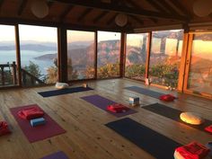 there are many yoga mats on the floor in front of large windows with mountains outside