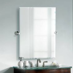 a bathroom vanity with a mirror and two faucets on it's side