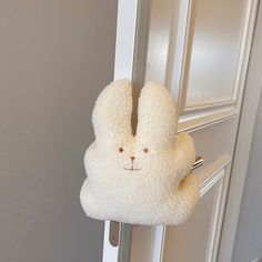 a white stuffed animal hanging on the side of a door