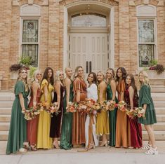 a group of women standing next to each other in front of a building with flowers