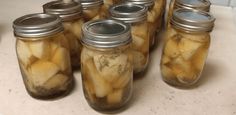 several jars filled with pickles sitting on top of a counter