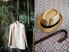 a hat, cane and coat hanging on a wall next to a bamboo plant with an umbrella