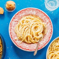 a bowl of pasta and two bowls of muffins on a blue table