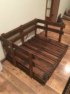 a bed frame made out of wooden planks on the floor in front of a door