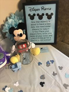 a mickey mouse stuffed animal sitting on top of a table next to a baby bottle