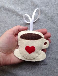 a hand holding a felt coffee cup ornament