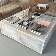 a coffee table with books and an owl on top