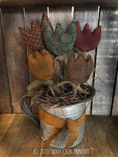 an old tin can with some knitted birds in it