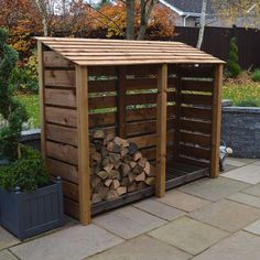 a wooden shed with logs stacked in it