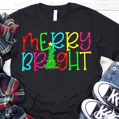 a t - shirt with the words merry bright on it next to some shoes and scarves