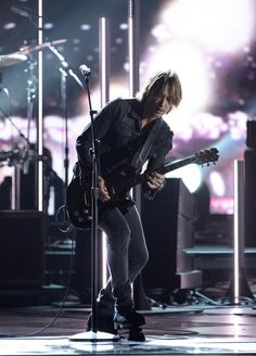 a man with a guitar on stage at a concert