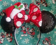 the minnie mouse ears are decorated with red sequins and santa claus's hat