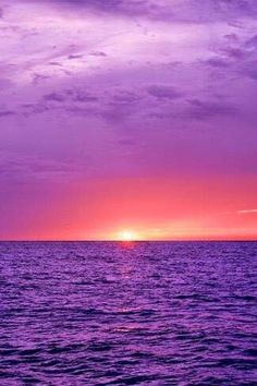 the sun is setting over the ocean with purple and pink hues in the sky