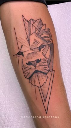 a lion head tattoo on the leg with geometric lines and triangles around it's face