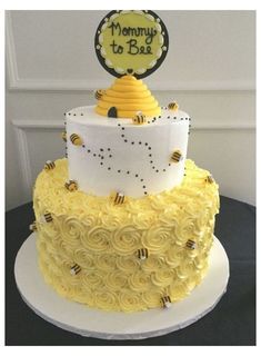 a yellow and white cake with a baby's name on top that says mommy to bee