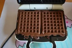 two waffles sitting on top of a table next to a toaster oven