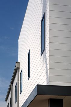 the side of a white building with black windows