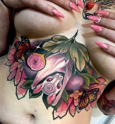 a woman's stomach with tattoos and flowers on the side, including an apple