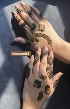 two hands with hendi designs on them and one holding the other's hand