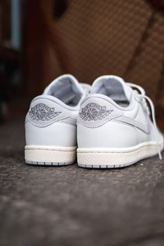 To celebrate the Air Jordan 1's 40th anniversary, Jordan Brand introduces the Air Jordan 1 Low '85 "Neutral Grey." This retro-inspired sneaker features a classic white and grey colour scheme with slightly aged midsoles for a nostalgic touch. The design stays true to the original eight lace holes setup and incorporates larger grey suede Swooshes. Iconic details like the Nike Air logo on the tongue, Jordan Wings on the suede heel panel, and perforated toe boxes remain. A grey concentric rubber outsole completes the look, making it an ideal staple choice. Leather Uppers Rubber Outsole Grey Colour Scheme, Jordan Wings, Air Logo, Air Jordan 1s, Grey Color Scheme, Air Jordan 1 Low, Billionaire Boys Club, Grey Suede, Jordan 1 Low