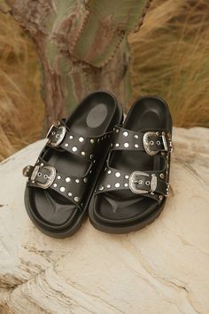 The Devaney Black Studded Western Buckle Slide Sandals were made for effortless styling, so you can spend more time out in the sun having fun! These faux leather sandals feature an almond-shaped footbed and wide adjustable straps embellished with silver studded details and Western-inspired buckles and tips with intricate embossing. A contoured insole completes the simple slide-on design. 0. 75" rubber sole. Smooth insole. Rubber sole has nonskid markings. Man made materials. Imported. Lulus | De Western Buckles, Spring Break Outfit, Black Slides, Almond Shaped, Buckle Sandals, Girls Sandals, Time Out, Having Fun, Slide Sandals