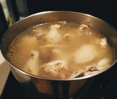 a pot filled with soup sitting on top of a stove