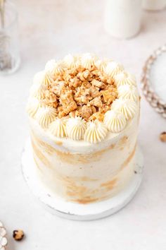 a close up of a cake with icing and nuts on the top, surrounded by other desserts