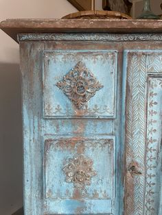 an old blue cabinet with ornate carvings on it