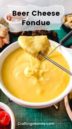 a person dipping cheese into a bowl with other foods in the background and text overlay that reads beer cheese fondue