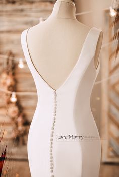 the back of a white dress with pearls on it