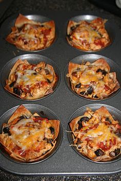 six mini pizzas sitting in a muffin tin