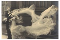 an old black and white photo of a man and woman in wedding gowns with birds flying over them