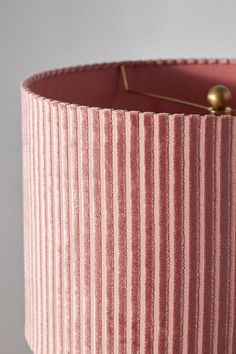 a pink lamp shade with gold pins on it