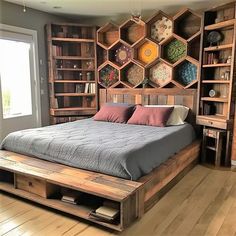 a bed made out of pallet wood with lots of shelves on the wall behind it