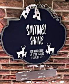 a sign that says samuel shane for this child and is hanging on the brick wall