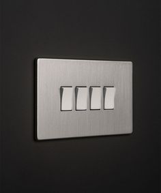 three light switches on a black wall