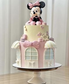 a pink and white cake with a minnie mouse on top