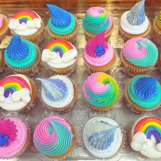 there are many cupcakes that have been decorated with icing and rainbow colors