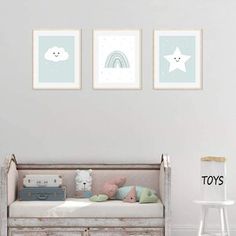 a baby's room with two pictures on the wall and a toy chest in the foreground