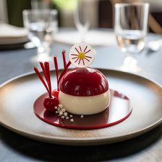 a plate topped with a dessert covered in red and white icing on top of a table