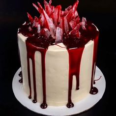 a white cake with red icing and drizzles on it