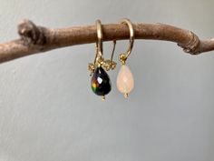 Black and white Ethiopian fire opal teardrops, with flashes of red, gold, green and pink under strong light. On our signature 18k gold plated half hoops Opal Teardrop Earrings As Gift, Teardrop Opal Earrings As A Gift, Teardrop Opal Earrings For Gift, Teardrop Opal Earrings In Gold, Black Enamel Drop Earrings, Gold Ethiopian Opal Earrings For Gift, Elegant Black Enamel Hoop Earrings, Black Opal Earrings, Black Tourmaline Earrings