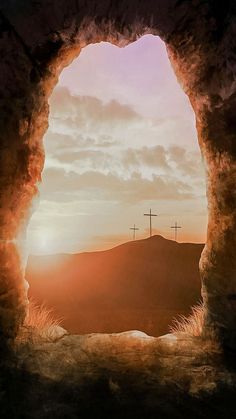 the sun is setting behind three crosses on top of a hill with hills in the background