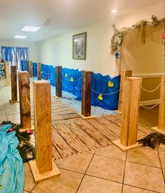 the room is being decorated with blue tarp and wooden poles for decoration, including wood posts