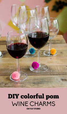 several wine glasses with different colored pom - poms on them and the words diy colorful pom - pom wine charms