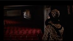 a woman standing in front of an empty theater with her back turned to the camera