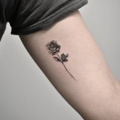 a single rose tattoo on the left arm