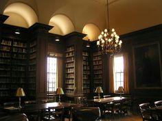 an empty library with tables and chairs in front of two large bookshelves filled with books