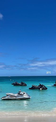 several jet skis are in the water on a beach