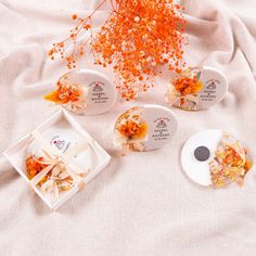 four pieces of cake sitting on top of a white table cloth next to orange flowers